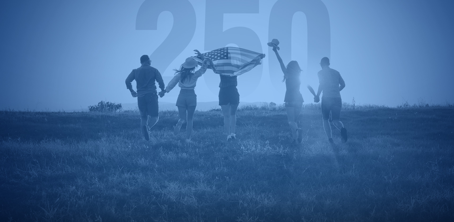 A group of people running through a field waving the American flag for the 4th of July